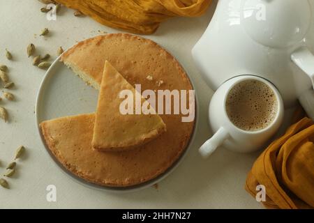 Scheibe Ghee-Kuchen. Eine Version von Teekuchen mit Ghee und Kardamom gewürzt. Perfekt zu einer Tasse heißen Tee. Aufgenommen auf weißem Hintergrund. Stockfoto