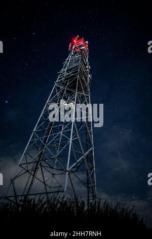 Turm für mobile Kommunikationssysteme 4G und 5G auf dem Hintergrund des Sternenhimmels. Basisstation nachts Stockfoto