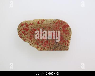 Glasintarsienfragment einfarbig 1st Hälfte des 1st. Jahrhunderts n. Chr. römisch-opak-rot.flache Intarsienplatte, mit einem abgerundeten Ende; Unterseite uneben; Kanten leicht abgeschrägt; Oberseite poliert und gerader Rand; Lochfraß und Oberflächenrisse auf der Oberseite; schwarze und grüne Verwitterung mit leichter Irideszenz auf der Unterseite; Ähnliche Verwitterung auf allen, aber gerade Kante.. Einfarbiger Glaseinlegefragment. Roman. 1st Hälfte des 1st. Jahrhunderts A.D.. Glas; Guss. Frühkaiserlich, Julio-Claudian. Glas Stockfoto
