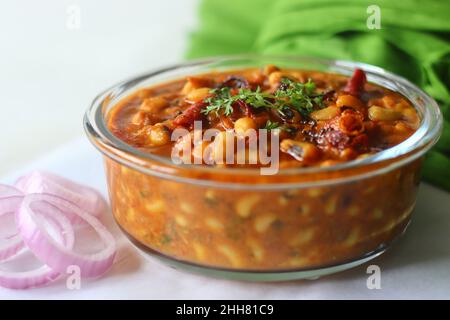 Schwarze Bohnen oder Kuhpfeienbohnen mit Soße. Die Soße wird mit Zwiebeln, Tomaten und Gewürzen gekocht und durch Zugabe von gerösteter Kokosnuss- und Zwiebelknoblauchpaste. Sho Stockfoto