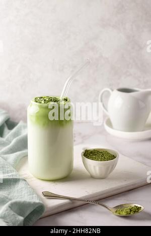 Grüner Tee mit Schaum in Glas, Dalgona Matcha Latte aus Schlagsahne und Milch auf weißem Hintergrund. Stockfoto