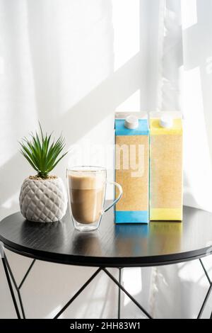 Kaffeetasse mit Kaffee und alternativer Milch. Milch aus Kartoffeln, Hafer, Mandeln, Reis, Nüssen, Und Sojabohnen sind in Coffee Shops alltäglich geworden. Milchverpackungsmockup. Stockfoto