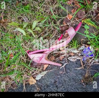 Verlassene und verlorene rosa Frauenschuh in einer Gasse Stockfoto