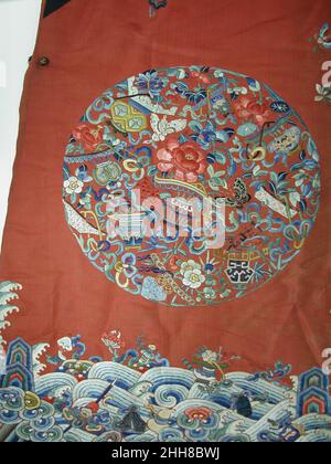 Festliche Robe der Frau 18th oder China des frühen 19th. Jahrhunderts Diese warm gepolsterte zeremonielle Robe mit Rundeln wäre von einer Mandschu-Frau zu den Feierlichkeiten der Wintermonate getragen worden, Aber die gestickten Blumen in dekorativen Behältern stammen aus allen Jahreszeiten, darunter ein Lotus für den Sommer, eine Chrysantheme für den Herbst, Nandinabeeren für den Winter und Pflaumenblüten für den Frühling sowie die ausgewachsene Pfingstrose mit einer Orchidee in der mittleren Vase. Feierlicher Gewand der Frau. China. 18th oder Anfang 19th Jahrhundert. Seide. Qing-Dynastie (1644–1911). Kostüme-Bestickt Stockfoto