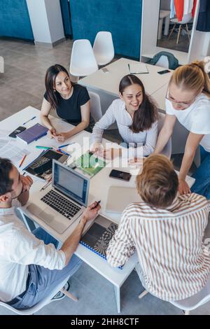 Die Schüler sitzen am Schreibtisch und reden während des Unterrichts. Stockfoto