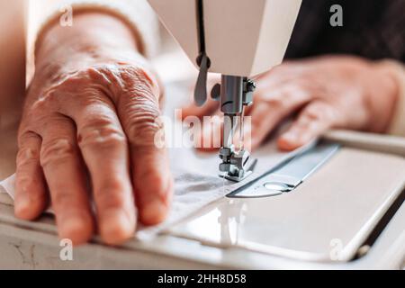 Nahaufnahme von Frauen, die auf der Nähmaschine handnähen. Stockfoto