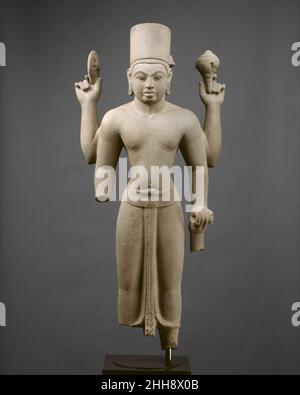 Stehende vierarmige Vishnu zweite Hälfte des 7th. Jahrhunderts Vietnam (Mekong-Delta-Gebiet) Dieses herausragende Beispiel des vorangkor-Stils stammt aus dem Königreich Zhenla im Mekong-Delta in Südvietnam. Es bewahrt den Geschmack der indischen Skulptur, vor allem in den vollen, runden Formen des Gesichts. Vishnus Kopfschmuck ist die orthodoxe Hochmitra. Er hält eine Muschel (Shankha) in seiner erhobenen linken Hand und einen Kriegsdiskus (Chakra) in seiner rechten. Seine abgesenkte linke Hand ruht auf den Resten einer Keule (Gada). Ursprünglich gab es strukturelle Stützen zwischen den Seiten der Gehrung und den oberen Emblemen. A p Stockfoto