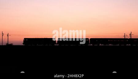 2 Lokomotiven der Baureihe 31 31454 + 31601 mit einer Railtour eine Sonnenuntergangs-Silhouette auf der Hauptlinie der Westküste machen Stockfoto