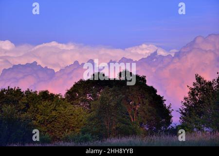 Bartlett, Illinois, USA. Schichten angesammelter Wolken am späten Nachmittag spiegeln an einem späten Frühlingsabend das Licht eines farbenfrohen Sonnenuntergangs wider. Stockfoto