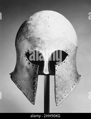 Bronzehelm des korinthischen Typs Ende des 6th. Jahrhunderts v. Chr. Griechisch der charakteristischste griechische Helm ist der des korinthischen Typs. Es zeichnet sich durch die Aussparungen für die Augen, das schmale Nasenstück und die kleine Öffnung für Lippen und Kinn aus. Die Löcher um die Kanten sind für die Befestigung einer Verkleidung. Es begann um 700 v. Chr. verwendet zu werden, und es gibt bedeutende Beweise, um seinen Ursprung in Korinth zu belegen. Diese Art von Helm entwickelte sich in Form und wurde mit großer Kunst ausgeführt.. Bronzehelm vom korinthischen Typ. Griechisch. Spätes 6th Jahrhundert B.C.. Bronze. Archaisch. Bronzen Stockfoto