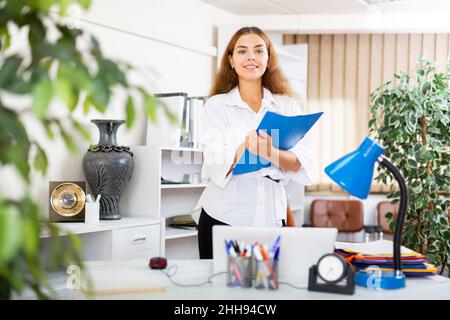 Buchhalterin, die neben dem Schreibtisch stand Stockfoto