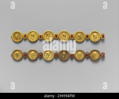 Gold Aurei der zwölf Caesars ca. 46 V. CHR.–N. CHR. 68 Roman die Münzen sind in einem passenden Paar Goldarmbänder aus dem 19. Jahrhundert montiert, die ebenfalls mit länglichen Amethysten en cabochon verziert sind. Der Schmuck mag von der Firma Castellani in Rom hergestellt worden sein und wurde von den Biographien der ersten zwölf Herrscher des kaiserlichen Roms, die mit Julius Caesar begannen und mit Domitian endeten, des Schriftstellers Suetonius aus dem frühen zweiten Jahrhundert n. Chr. inspiriert. Ein Armband enthält Aurei des Diktators Julius Caesar und der Julio-Claudianischen Kaiser Augustus, Tiberius, Caligula, Claudius und Nero, Das andere h Stockfoto