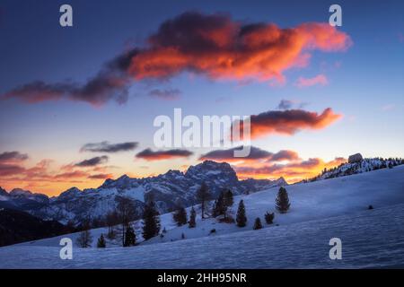 Malerisches Bild von einigen rosa Wolken über einer blauen Landschaft bei Sonnenaufgang im Passo Falzarego, einem Alpenpass in der Nähe von Cortina d'Ampezzo, Dolomiten, Italien Stockfoto