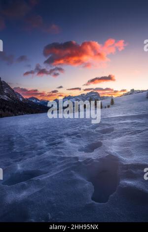 Malerisches Bild von einigen rosa Wolken über einer blauen Landschaft bei Sonnenaufgang im Passo Falzarego, einem Alpenpass in der Nähe von Cortina d'Ampezzo, Dolomiten, Italien Stockfoto