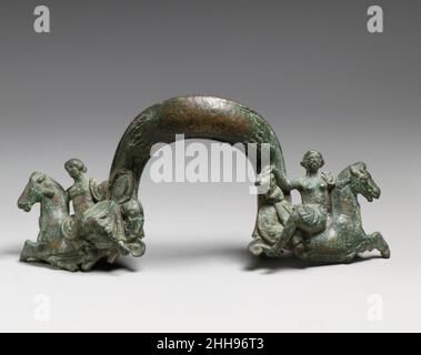 Bronzestiel eines seichten Beckens 4th Jahrhundert B.C. Griechisch die Befestigungen an jedem Ende des Bügels stellen Nereids dar, die Hippocamps (Seepferde) reiten und einen Schild und einen Kürass (Körperpanzerung) zu Achilles bringen. Da der mythologische Bezug auf das Meer besteht, könnte die Vase, zu der der Griff gehörte, Wasser enthalten haben – zum Beispiel ein Podaypter (Fußbecken). Bronzestiel eines flachen Beckens. Griechisch. 4th Jahrhundert v. Chr.. Bronze. Spätklassik. Bronzen Stockfoto