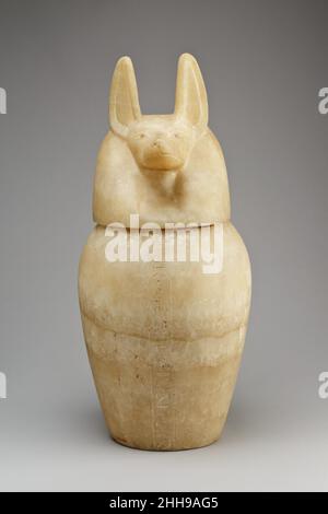Kanopieglas mit einem Schakalkopf-Deckel 664–525 v. Chr. in der späten Periode wurden Saite-Kanopiegläser hergestellt, um die einbalsamierten Eingeweide zu enthalten, die während der Mumifizierung aus dem Körper entfernt wurden. Die Organe wurden unter den Schutz der vier Söhne des Horus gestellt, deren Köpfe die Deckel der Gefäße bilden: Hapy (Paviankopf), Imsety (Menschenkopf), Duamutef (Schakalkopf) und Kebehsenuef (Falkenkopf). Diese Götter wiederum standen unter dem Schutz der Göttinnen Nephthys, Isis, Neith und Selket, Wie die Inschriften auf den Gefäßen sagen.Dieses Glas stand unter dem Schutz von Duamutef und Neith an Stockfoto
