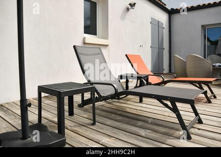 Zwei Sonnenliegen am Pool im Hof Stockfoto