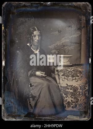 Harriet Beecher Stowe 1850s Southworth and Hawes American Diese viertlige Daguerreotypie der amerikanischen Autorin Harriet Beecher Stowe (1811-1896) entstand vermutlich um die Zeit der Veröffentlichung ihres einflussreichen Romans Uncle Tom's Cabin (1852). Das enorm erfolgreiche Buch, das die zutiefst religiöse Stowe behauptete, war das Ergebnis einer Vision von Gott, was maßgeblich dazu beitrug, die Anti-Sklaverei-Stimmung im Norden vor dem Bürgerkrieg zu fokussieren. Charmant gepaart mit einer zarten Topfpflanze in einer Szene, die ein ruhiges häusliches Interieur evoziert, wirkt Stowe klein und eher bescheiden – überraschend m Stockfoto
