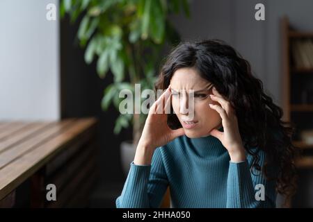 Besorgte Frau, die ängstliche Gedanken hatte, gestresste junge Frau, die unter Angstkopfschmerz litt Stockfoto