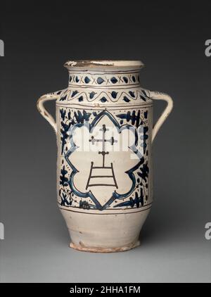 Apotheke Jar mit den Armen des Krankenhauses von Santa Maria della Scala 1425–50 Italienisch Eine kurze, von einem Kreuz überragte Leiter war das Emblem des Krankenhauses von Santa Maria della Scala in Siena, wo es vor der Treppe (scala) der Kathedrale der Stadt stand. Das Krankenhaus hatte auch eine Zweigstelle in Florenz, und diese Arbeit hätte als Medikamentenbehälter in der Apotheke eines der beiden Standorte dienen können. Apotheke Jar mit den Armen des Krankenhauses von Santa Maria della Scala. Italienisch. 1425–50. Zinnverglaste Steingut. Hergestellt wahrscheinlich in Siena, Toskana, Italien. Keramik Stockfoto