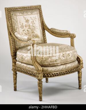 Sessel (Fauteuil à la reine) (ein Paar) (Teil eines Sets) ca. 1780–85 Georges Jacob Französisch das Museum verfügt über zwei Sessel (fauteuils à la reine) und zwei Seitenstühle (Chaises courantes), die um 1780 von Jacob hergestellt wurden; einer der Sessel ist hier zu sehen. Die geschnitzten und vergoldeten Rahmen zeigen die Finesse der Holzschnitzer-Technik. Die Stücke sind mit weißem Seidensatin gepolstert, bestickt mit farbigen Seiden; das Design ist im Stil von Philippe de la Salle, dem prominentesten Designer von Seidengeweben der Zeit. Sessel (Fauteuil à la reine) (ein Paar) (Teil eines Sets) Stockfoto