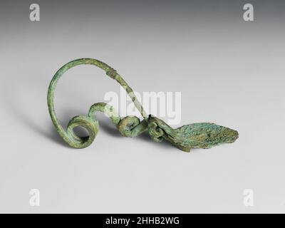 Bronze-Serpentinscheibenfibel (Sicherheitsnadel) 9th. Jahrhundert v. Chr. Villanovan Es gibt zwei Spiralen, eine von einer Umdrehung, die andere von zwei. Die Scheibe besteht aus einem flachen Stück Metall, das einmal spiralförmig gerollt wurde. Bronze-Fibel mit Serpentinenscheibe (Sicherheitsstift) 246373 Stockfoto