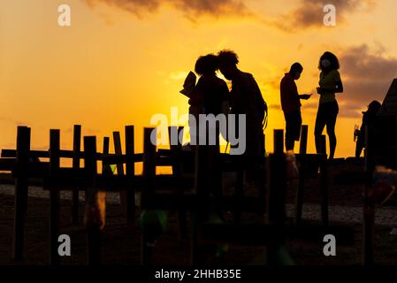 Silhouette von Menschen und Kreuzen, die auf dem Boden zu Ehren der von Covid-19 Getöteten befestigt sind. Sonnenuntergang in Salva Stockfoto