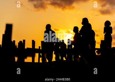 Silhouette von Menschen und Kreuzen, die auf dem Boden zu Ehren der von Covid-19 Getöteten befestigt sind. Sonnenuntergang in Salva Stockfoto