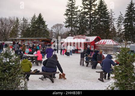 Ottawa, Ontario, Kanada - 22. Januar 2022: Menschen versammeln sich um Picknicktische und stellen sich auf dem Rideau Canal Skateway für BeaverTails an. Stockfoto