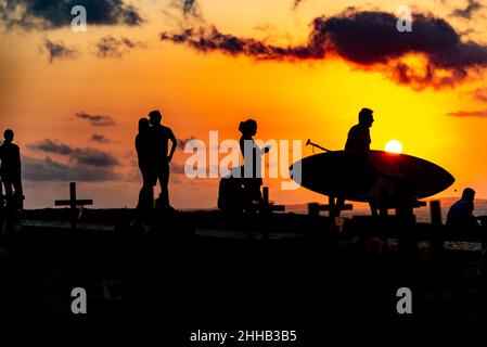 Silhouette von Menschen und Kreuzen, die auf dem Boden zu Ehren der von Covid-19 Getöteten befestigt sind. Sonnenuntergang in Salva Stockfoto