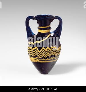 Glas Amphoriskos (Parfümflasche) Ende 4th–Anfang 3rd Jahrhundert v. Chr. Griechisch, östliches Mittelmeer oder Italienisch Durchscheinend dunkles Kobaltblau, schwarz, mit gleichen farbigen Griffen; einfarbige Spur in opakendem Gelb. Horizontaler Rand mit abgerundeter Kante und strahlenden Werkzeugmarkierungen auf der Oberseite; zylindrischer Hals; breite, schräge Schulter; eiförmiger Körper; spitz zulaufender Boden; Zwei vertikale Gurtgriffe auf der Schulter, die in einer Kurve gezogen, dann gedreht und an der Oberseite des Halses und der Unterseite des Randes befestigt werden.Trail unter dem Rand aufgetragen, spiralförmig zweimal um den Hals gewickelt und über die Schulter zum Körper hingezogen, zu einem eingearbeiteten Stockfoto