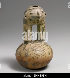 Gesichtshalsflasche 10th–16th Century Quimbaya Dieses auffällige Gefäß ist eine Steigbügelflasche mit einem Gesicht an der Oberseite der Auslauföffnungen, eine in Kolumbien relativ ungewöhnliche Form. Es wurden jedoch Beispiele unter den Grabbeigaben im Gebiet des mittleren Cauca-Flusses gefunden. Die verbundenen Ausbrüche auf diesen Flaschen bilden unweigerlich einen menschlichen Kopf mit modellierten Merkmalen, die denen der vollfigurigen Gefäße der Region ähneln. Die Flasche öffnet sich oben auf dem Kopf wie ein Beispiel in voller Figur. Die Ohren und die Nase sind durchbohrt, um Ornamente zu halten. Die dicken Ausführungen und die Kugelkammer tragen ein charakteristisches geometrisches Resist-Design Stockfoto