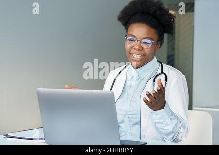 afroamerikanische junge Ärztin, die Patienten online mit einem Laptop berät Stockfoto