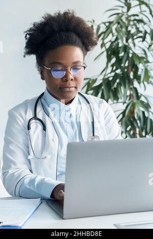 Afroamerikanischer Arzt mit Laptop-Computer in der medizinischen Arbeit oder Ausbildung Stockfoto
