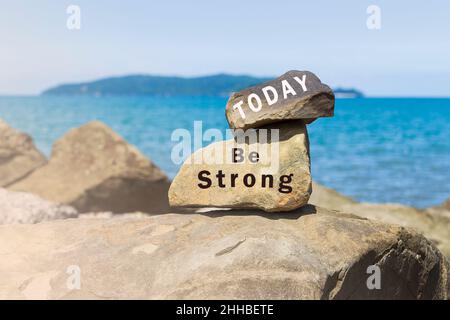 Inspirierender Text auf Steinen am Strand mit Meerblick Stockfoto