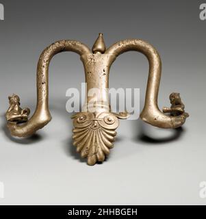 Griffe und Füße eines bronzenen Louterions (Becken) 1st Viertel des 5th. Jahrhunderts B.C. Griechisch die drei Füße sind in der Form von Löwenpfoten. Die Griffe enden in liegendem Satyrs (Anhänger des weingottes, Dionysos), die Trinkhörner halten. Die Ikonographie ist üblich für ein Objekt, das Wasser enthielt. Griffe und Füße eines Bronzeglouterions (Becken) 255015 Griechisch, Griffe und Füße eines Bronzeglouterions (Becken), 1st Viertel des 5th. Jahrhunderts v. Chr., Bronze, Füße, a-c: 3 1/4 ? 3 5/8 Zoll (8,3 ? 9,2 cm) Griffe, d-e: 6 1/16 ? 6 3/4 ? 3 Zoll (15,4 ? 17,1 ? 7,6 cm). Das Metropolitan Museum of Art, New Y Stockfoto