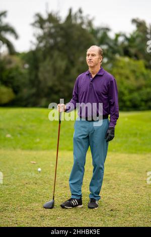 Golfer posiert für das Foto auf einem Golfplatz Stockfoto