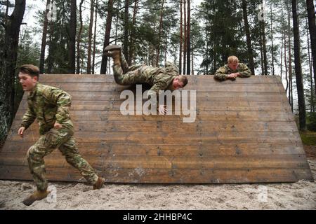 Grafenwoehr, Bayern, Deutschland. 14th Dez 2021. Fallschirmjäger der US-Armee, die 1st Squadron, 91st Kavallerieregiment, 173rd Airborne Brigade zugewiesen wurden, erobern eine schräge Wand am Hindernisparcours während einer Spornfahrt auf dem Trainingsgelände des 7th Army Training Command in Grafenwoehr, Deutschland, 14. Dezember 2021. Der Zweck dieser Spornfahrt ist es, neue Fallschirmjäger in die Luftgetragene Kavallerie zu integrieren und innerhalb der Staffel einen Esprit de Corps aufzubauen, der sich auf das Erbe der Kavallerie konzentriert. Kredit: U.S. Army/ZUMA Press Wire Service/ZUMAPRESS.com/Alamy Live Nachrichten Stockfoto