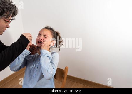 Mutter nimmt zu Hause einen schnellen Covid-19-Test bei ihrer Tochter ab. Stockfoto