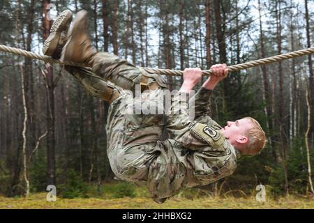 Grafenwoehr, Bayern, Deutschland. 14th Dez 2021. Ein Fallschirmjäger der US-Armee, der 1st Squadron, 91st Kavallerieregiment, 173rd Airborne Brigade zugewiesen wurde, erobert die Seilbrücke während des Hindernisparcours-Teils einer Spornfahrt auf dem Trainingsgelände des 7th Army Training Command in Grafenwoehr, Deutschland, 14. Dezember 2021. Der Zweck dieser Spornfahrt ist es, neue Fallschirmjäger in die Luftgetragene Kavallerie zu integrieren und innerhalb der Staffel einen Esprit de Corps aufzubauen, der sich auf das Erbe der Kavallerie konzentriert. Kredit: U.S. Army/ZUMA Press Wire Service/ZUMAPRESS.com/Alamy Live Nachrichten Stockfoto