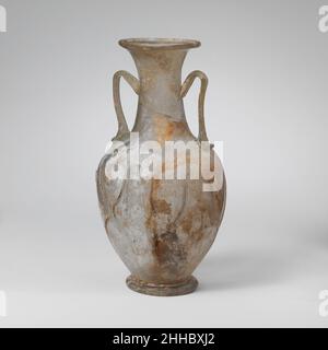 Amphora aus Glas (zweihandige Flasche) 4th. Jahrhundert n. Chr. römisch farblos mit hellgrünem Farbton; Griffe und Spuren in derselben Farbe. Abgerundeter Rand, ausgeklappt, über und in; aufflackernder Mund; Zylindrischer Hals, nach unten ausdehnend; schräge Schulter; piriformer Körper, nach unten zugeneigt; Integrierter, röhrenförmiger Sockelring; eingeschobene Unterseite mit abwegiger Pontil-Narbe; Die Griffe werden in einer umgerüstelten Unterlage an der Schulter angebracht, vertikal nach oben gezogen, in einem spitzen Winkel nach innen und unten gedreht und am Hals befestigt.Trails, die in sechs Paar welliger vertikaler Linien und einer zusätzlichen einzigen Linie am Körper angebracht werden, bilden unregelmäßige X-förmige Muster; Fire-r Stockfoto