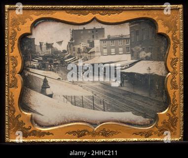 [Chatham Square, New York] 1853–55 Unbekannt Diese chaotische Straßenszene zeigt die Chatham Street, jetzt Park Row, von unterhalb ihrer Kreuzung mit der Pearl Street, nordöstlich zum Chatham Square. Im Gegensatz zu den gedruckten Ansichten der Zeit, die im Allgemeinen auf Klarheit ausgelegt und mit einer Anekdote an der Entwurfstabelle gefüllt waren, zeigt dieses Foto die Stadt als eine unelegante Verwirrung von Verkehr, Handelsschildern und Fußgängern. Es fängt den Geist der Straße ein, der "Innenstadt", wo der geschäftige, unmanierliche Handel mit Möbeln und Federn, Fensterblenden, Tee und sogar Daguerreotypen New Yorks Bekanntheit als hervorbrachte Stockfoto
