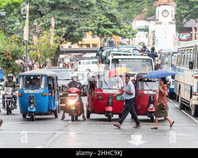 Fahrzeug wartet an einer Ampel, während Fußgänger an einem regnerischen Tag in Kandy in Sri Lanka die Straße überqueren. Stockfoto