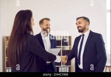 Glücklicher, lächelnder Kunde, der einem professionellen Anwalt oder Finanzberater die Hände schüttelt Stockfoto