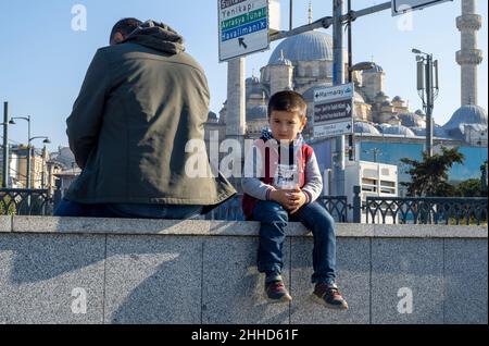 ISTANBUL - Okt 21: Kleiner türkischer Junge sitzt auf der Galata-Brücke in Istanbul, Oktober 21. 2021 in der Türkei Stockfoto