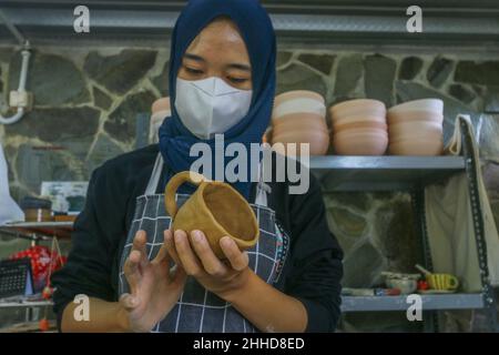 Eine Künstlerin stellt Tonwaren aus Ton im Mini Pottery Studio, Kota Bogor, Indonesien, 22. Januar 2022 her Stockfoto