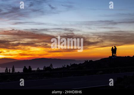 Touristen beobachten den dramatischen Sonnenuntergang hinter den Inseln El Hierro und La Gomera aus einer Höhe von etwa 2000 Metern über dem Meeresspiegel Stockfoto