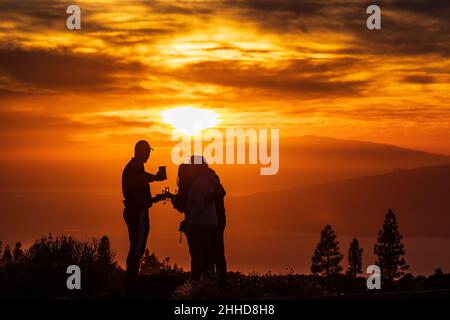 Touristen beobachten den dramatischen Sonnenuntergang hinter den Inseln El Hierro und La Gomera aus einer Höhe von etwa 2000 Metern über dem Meeresspiegel Stockfoto