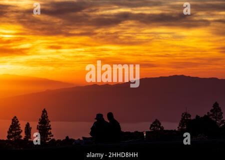 Touristen beobachten den dramatischen Sonnenuntergang hinter den Inseln El Hierro und La Gomera aus einer Höhe von etwa 2000 Metern über dem Meeresspiegel Stockfoto