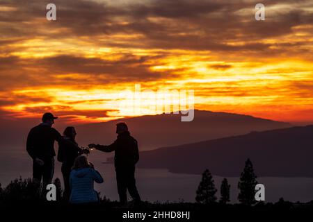 Touristen beobachten den dramatischen Sonnenuntergang hinter den Inseln El Hierro und La Gomera aus einer Höhe von etwa 2000 Metern über dem Meeresspiegel Stockfoto